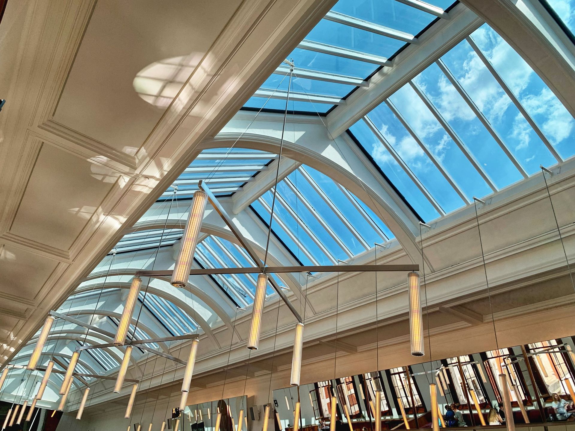 A stunning view of a contemporary hallway with a glass ceiling and bright natural light.